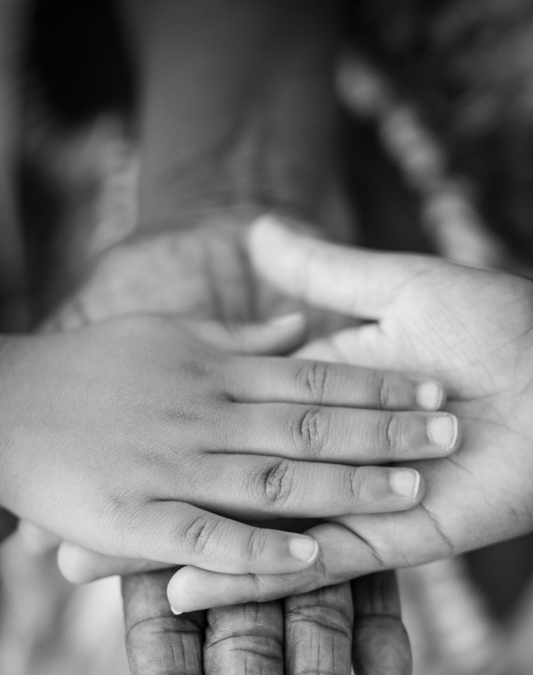 Mains enfant, femme et homme empilées en noir et blanc