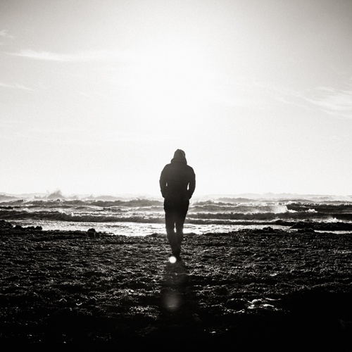 homme de dos marchant vers la mer